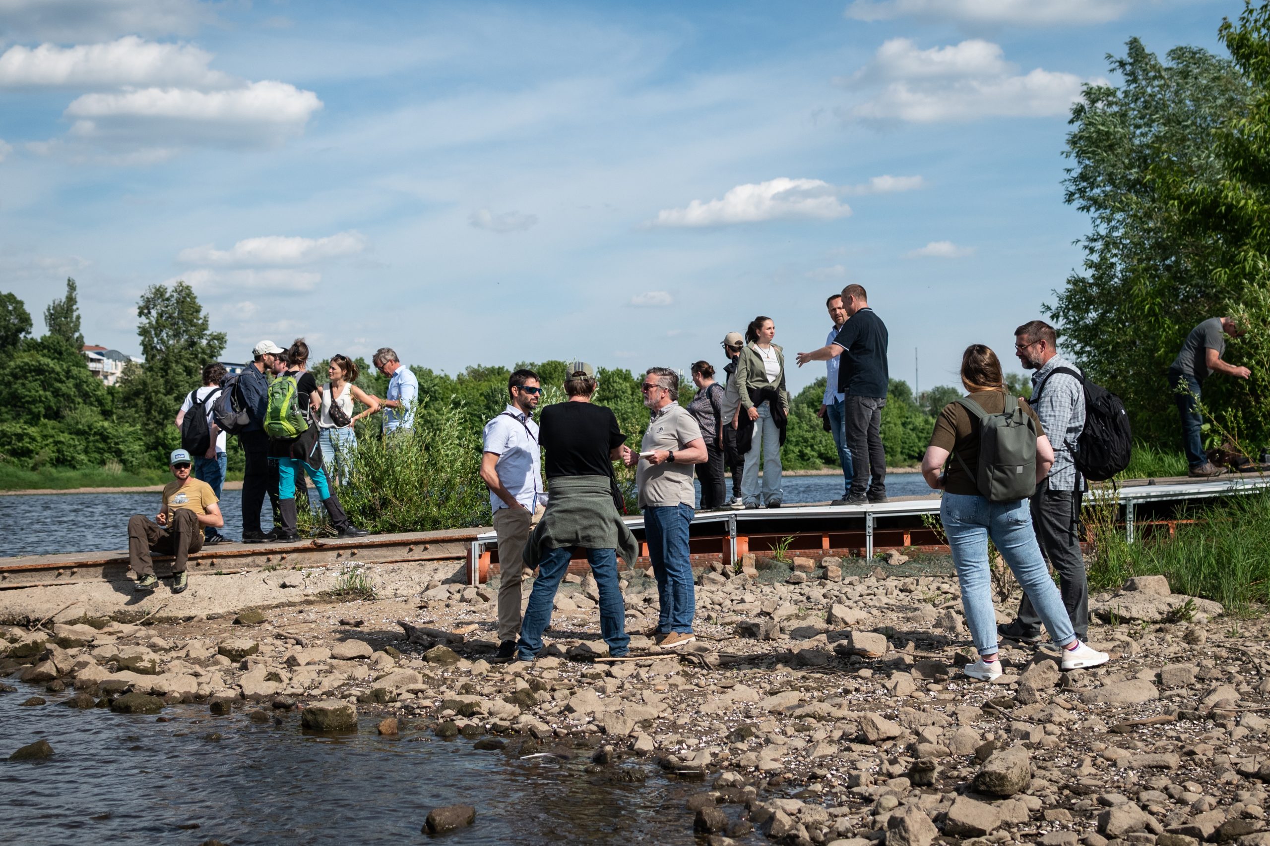 Scientists discuss common concerns during a visit to a mitten crab trap on the River Elbe